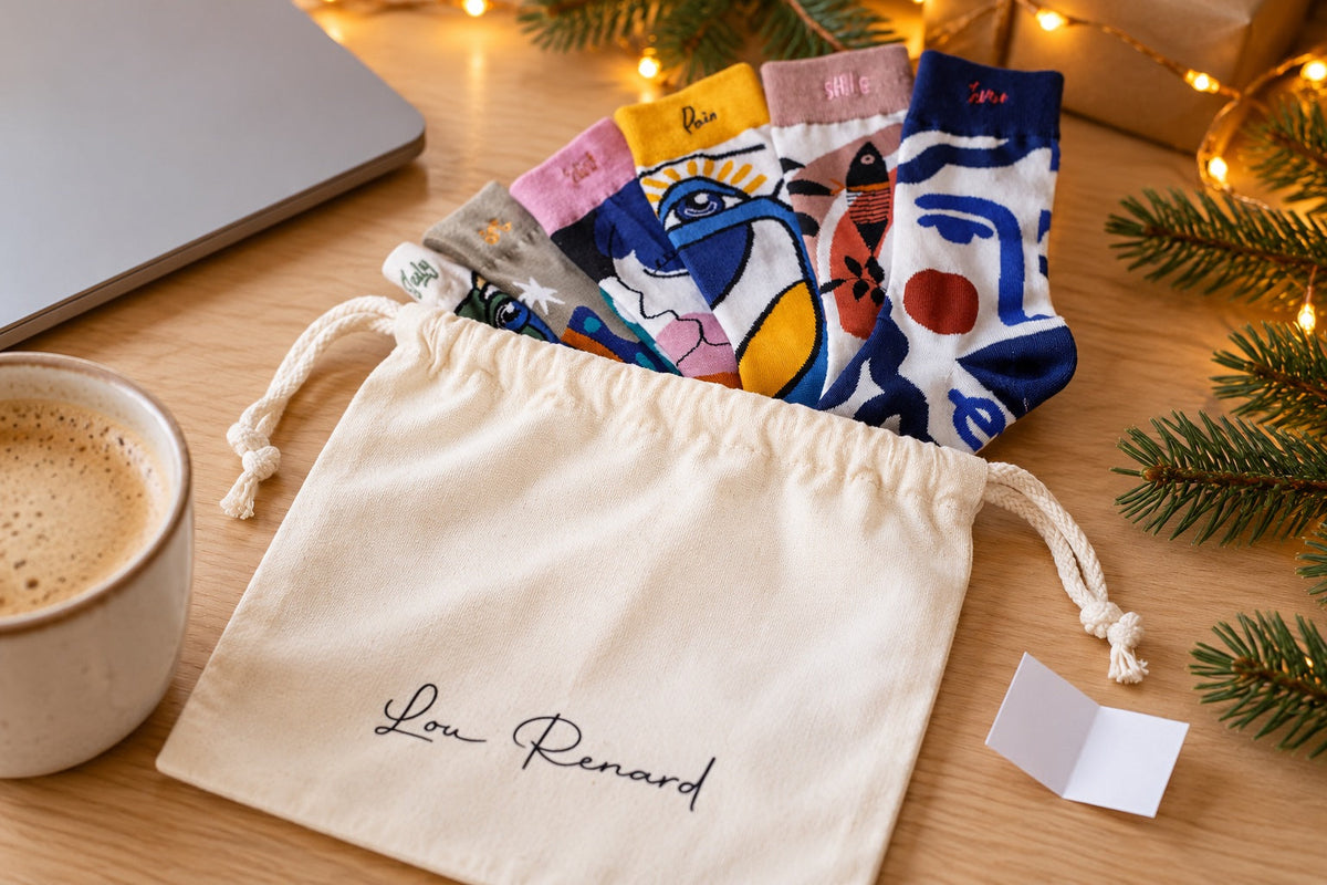 Cadeau Secret Santa : chaussettes L'Artiste dans le pochon en coton Lou Renard, posé sur un bureau